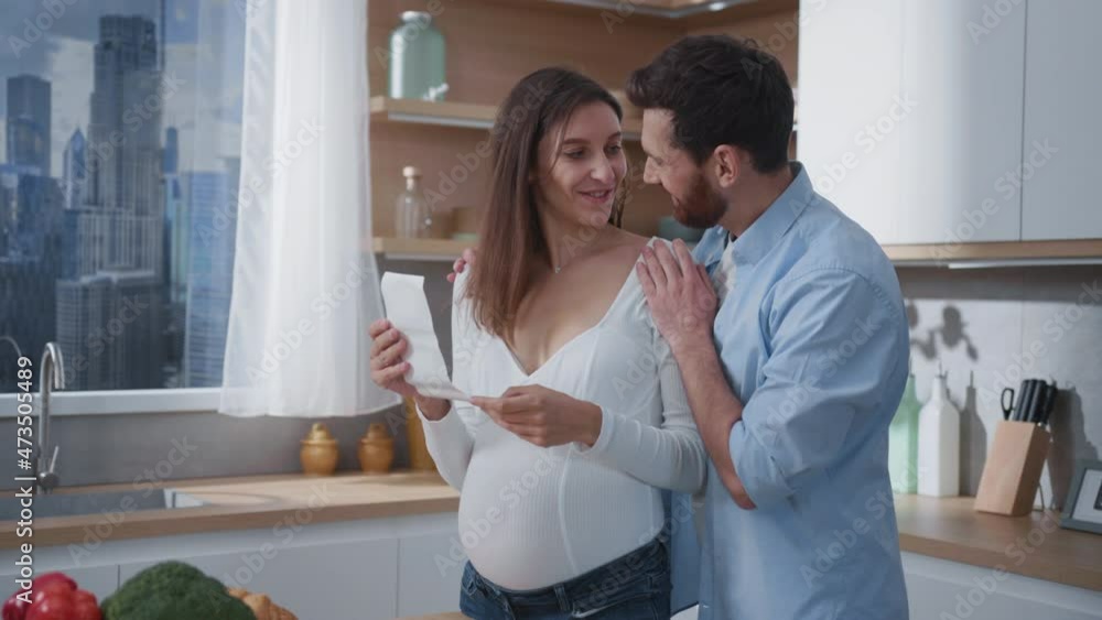 Happy caucasian young pregnant wife with husband embracing and watching ultrasonography screen of their little baby. Togetherness. Family. Relationship. Children. Happy caucasian young pregnant wife with husband embracing and watching ultrasonography screen of their little baby. Togetherness. Family. Relationship. Children.