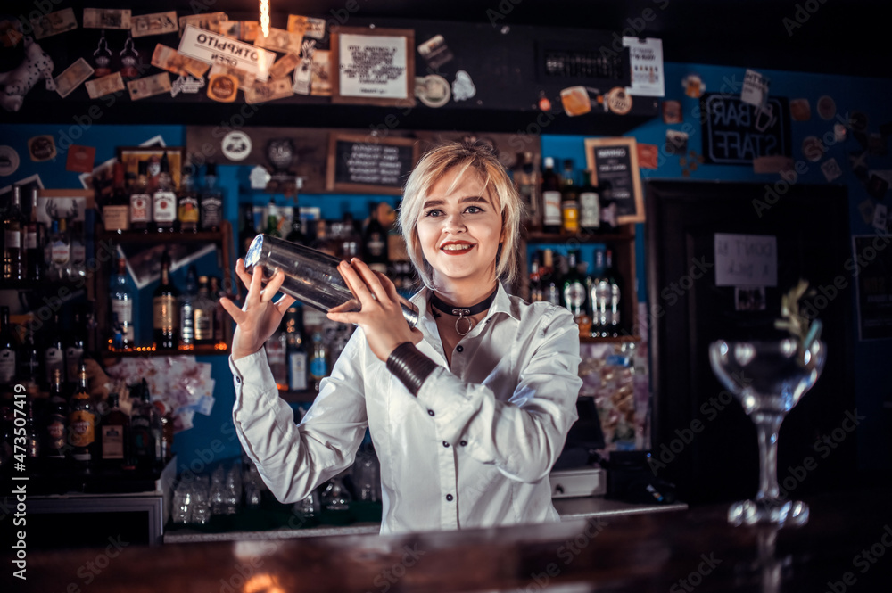 Girl barman creates a cocktail on the taproom