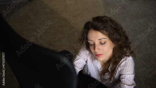 Young businesswoman with red lipstick and red high heels is climbing on a chair from the floor, female careerist