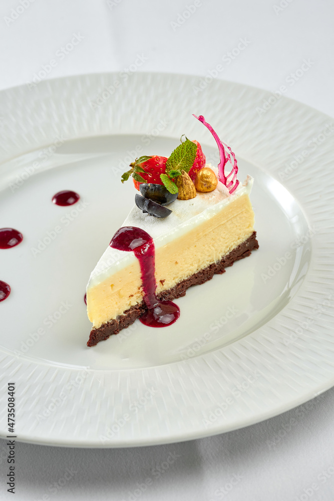 Cheesecake with sauce in a white plate on a white plate Cheesecake with sauce in a white plate on a white plate