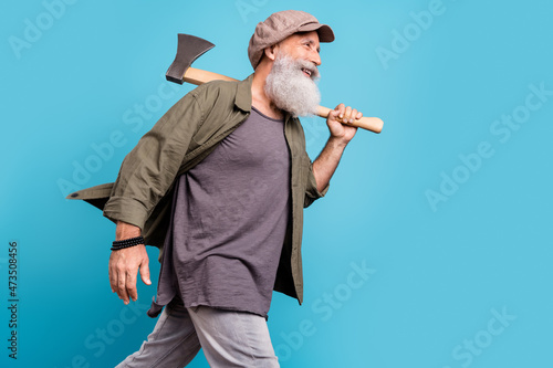 Canvas-taulu Profile photo of funny old man wearing khaki shirt cap do with wooden axe isolat