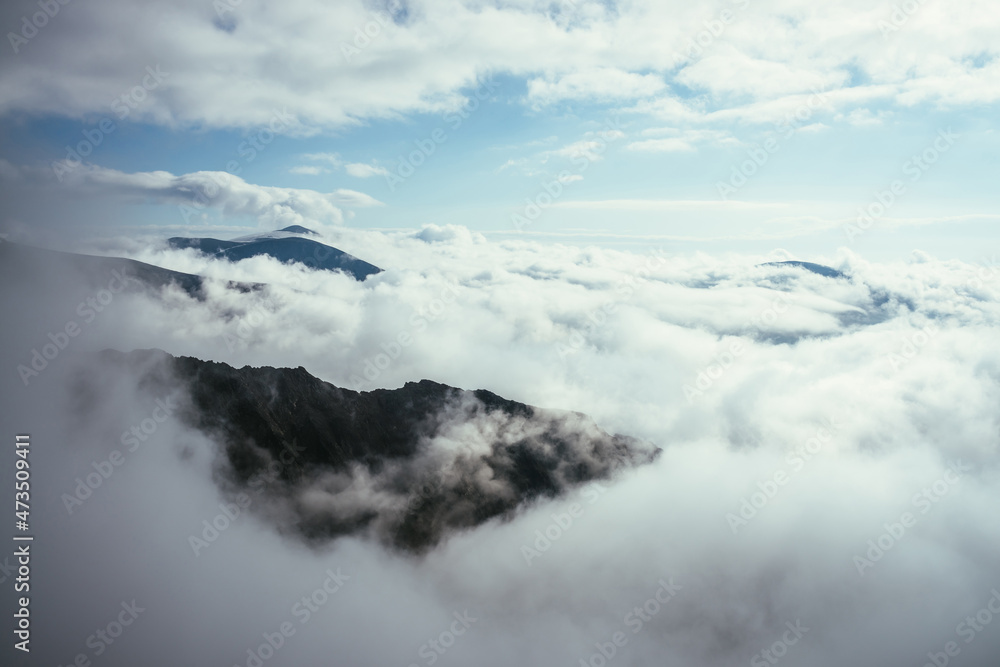 Wonderful alpine scenery with great rocks and mountains in dense low clouds. Atmospheric highlands landscape with mountain tops above clouds. Beautiful view to snow mountain peaks over thick clouds. Wonderful alpine scenery with great rocks and mountains in dense low clouds. Atmospheric highlands landscape with mountain tops above clouds. Beautiful view to snow mountain peaks over thick clouds.