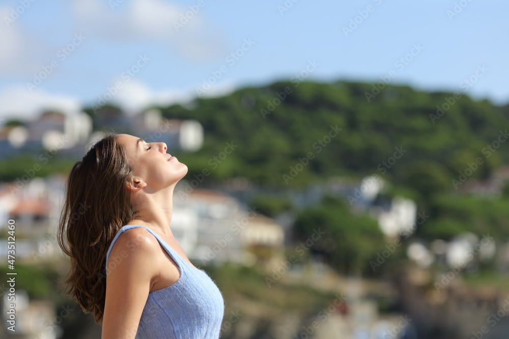 Profile of a woman breathing fresh air in a mountain town Profile of a woman breathing fresh air in a mountain town