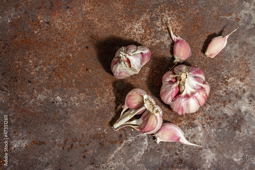 Fotografía Fresh ripe garlic cloves on a rusty metal background, close up