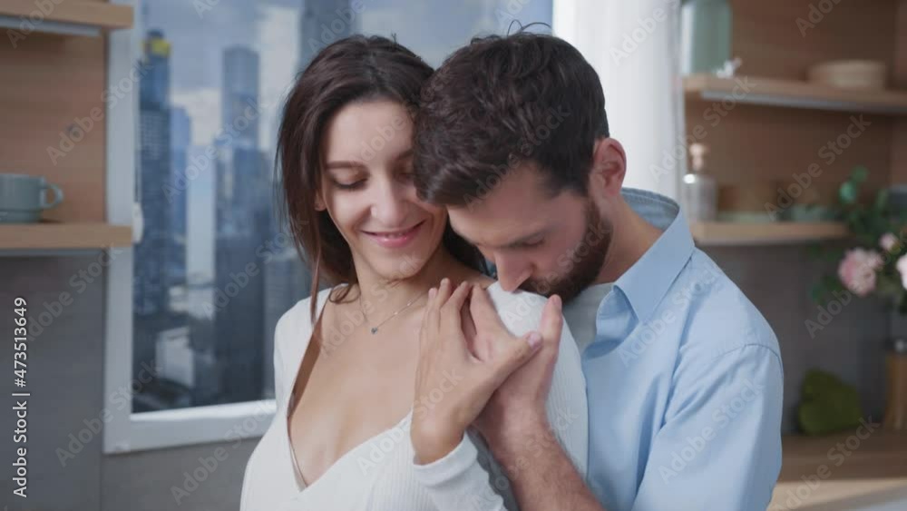 Handsome joyful couple of future parents expecting child holding hands together gently touching baby belly at home. Interiors. Kitchen. Relationship. Families. Handsome joyful couple of future parents expecting child holding hands together gently touching baby belly at home. Interiors. Kitchen. Relationship. Families.