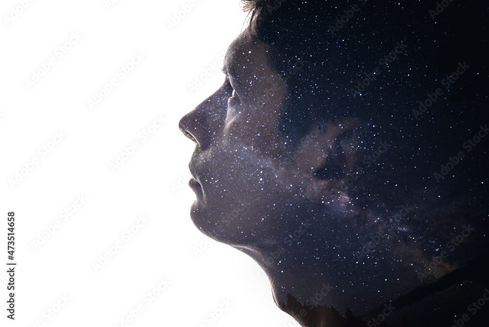 Combination of the silhouette of a man face and space with stars. Concept of the connection between man and the universe