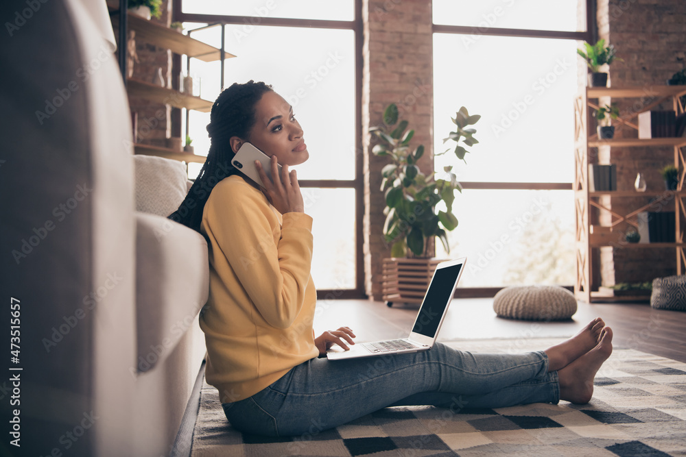 Photo of sweet shiny young woman dressed yellow sweater sitting floor talking modern device indoors home room Photo of sweet shiny young woman dressed yellow sweater sitting floor talking modern device indoors home room