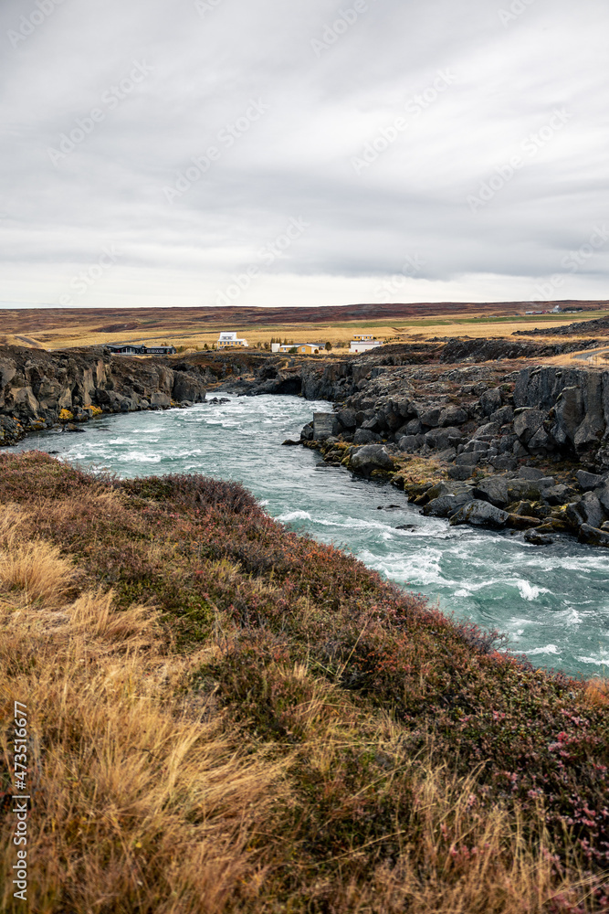 Goðafoss Waterfall Iceland with yellow grass and green blue river