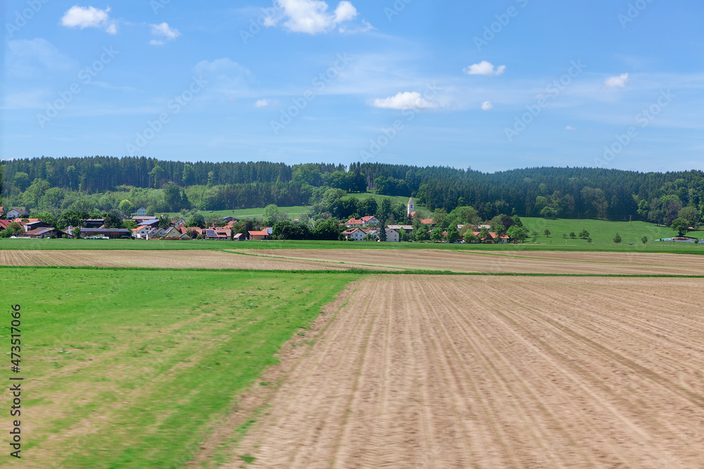 Village and agricultural field in Germany . Rustic springtime scenery . Plowing land in the spring 
