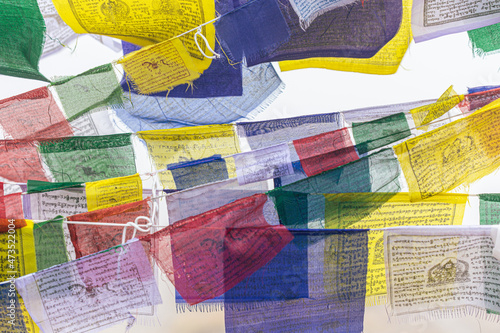 Long strings of colorful Tibetan prayer flags flutter in the wind somewhere in high foggy mountains in Nepal.