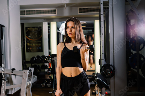 Beautiful young woman doing exercise and smiling at the gym with boxer gloves © Ivan Zelenin