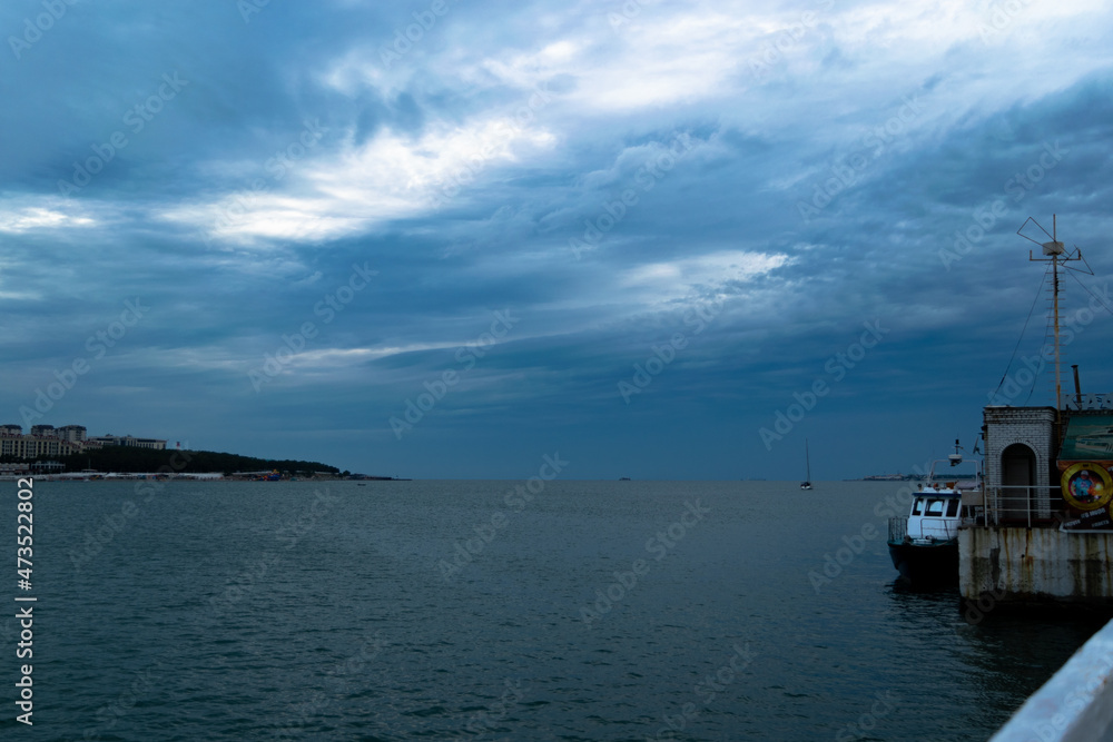 Gelendzhik Russia, gloomy beautiful blue sky and the black sea embankment and boats.