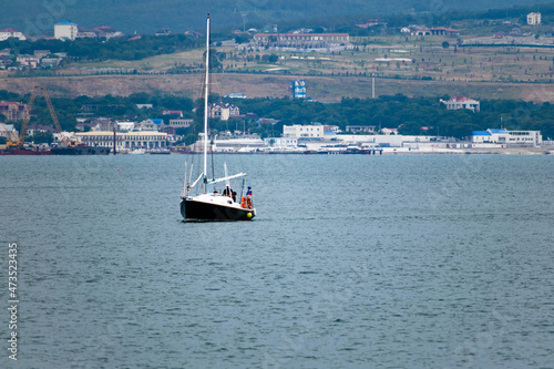 Boat at sea without sails, mountains in the background.