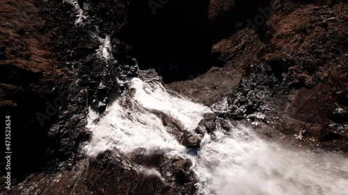 drone over cliffs to flowing waterfall of rjukandafoss photo