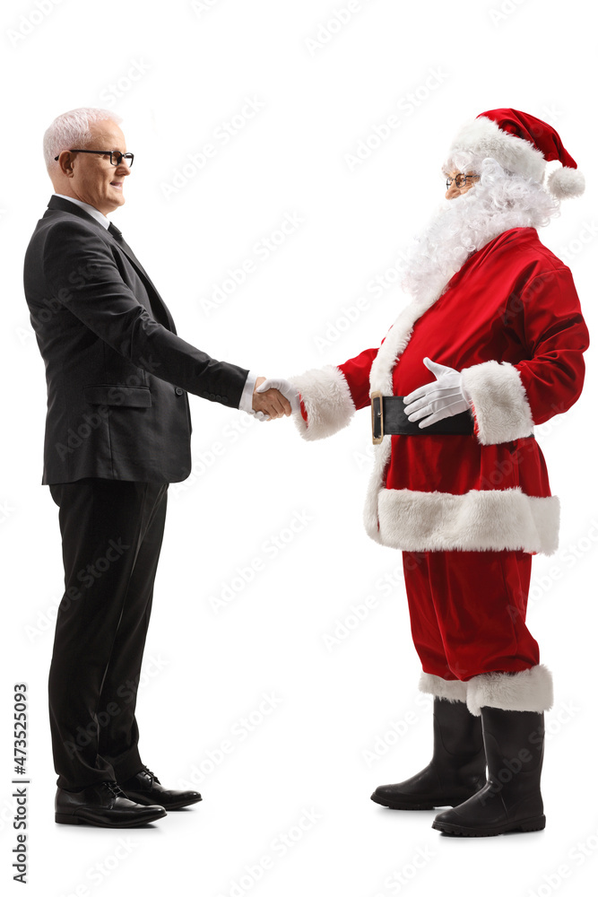Full length profile shot of a mature man in a suit and tie shaking hands with santa claus
