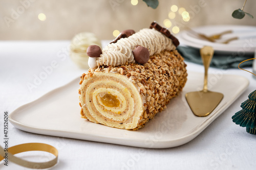 Buche de Noel. Traditional Christmas dessert, Christmas yule log cake with vanilla cream. Christmas tree branches.