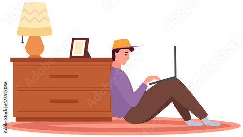 Distance learning, freelance and internet entertainment. Man sitting with laptop near chest of drawers at home. Remote work, online home freelancing concept. Online communication, internet surfing