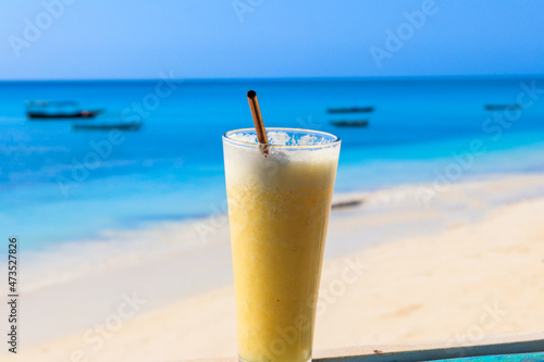 Glass of fresh juice by the ocean. Tropical vacations concept
