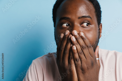Black bristle man expressing surprise and covering his mouth