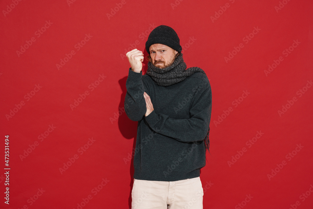 White man wearing warm clothes frowning while showing fist at camera White man wearing warm clothes frowning while showing fist at camera