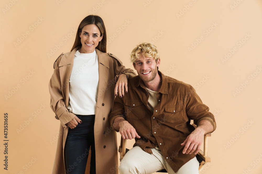 White blonde couple smiling at camera while posing together White blonde couple smiling at camera while posing together