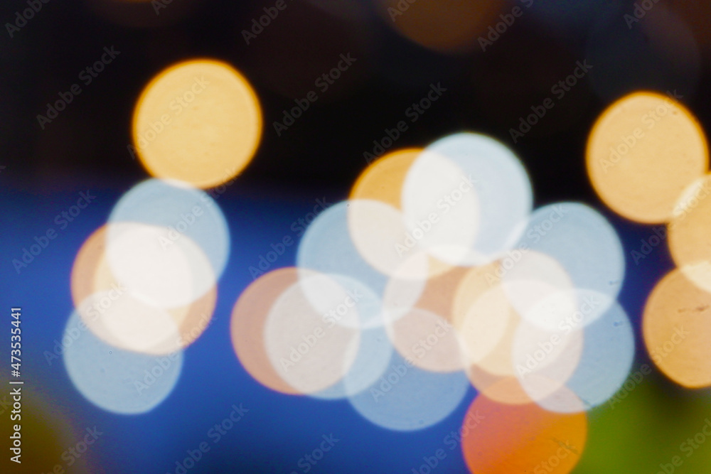 Colorful irregular blurred bokeh background from night lamps with black and blue background Colorful irregular blurred bokeh background from night lamps with black and blue background