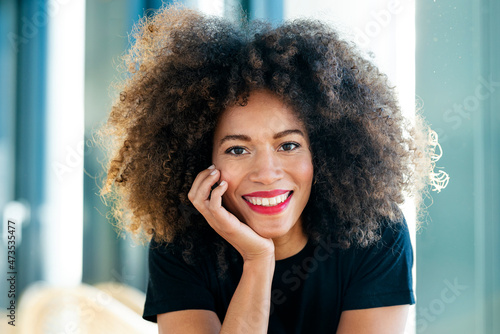 Smiling businesswoman with Afro hair in office photo