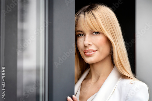 Beautiful blond businesswoman with bangs at window photo