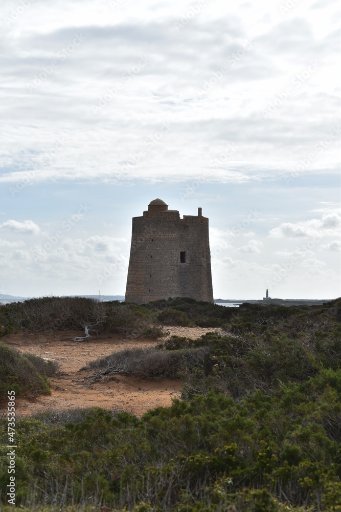 An old tower and a lighthouse in Las Salinas Natural Park, Ibiza