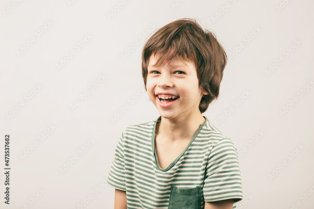 Happy six year old European boy portrait over grey Happy six year old European boy portrait over grey