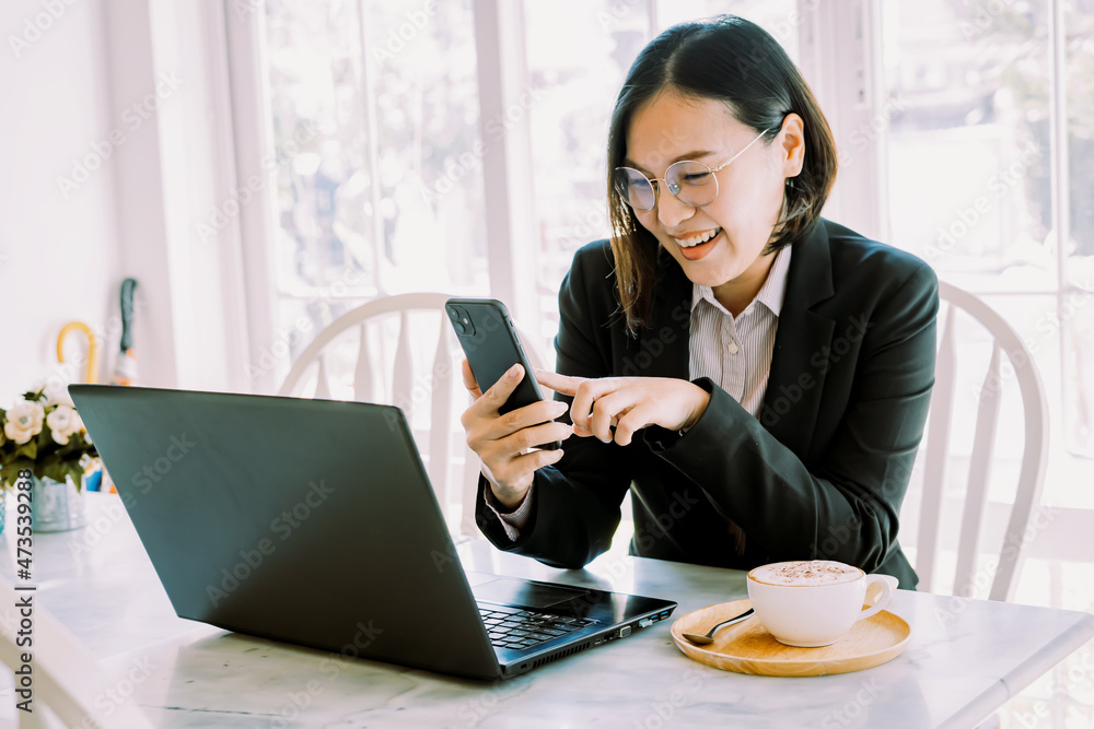 Woman working online through mobile phone and notebook computer. Woman working online through mobile phone and notebook computer.