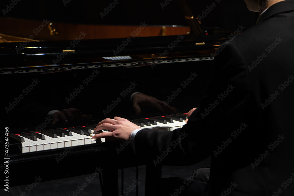 Professional pianist performing a piece on a grand piano. - obrazy, fototapety, plakaty 