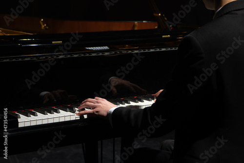 Professional pianist performing a piece on a grand piano. photo