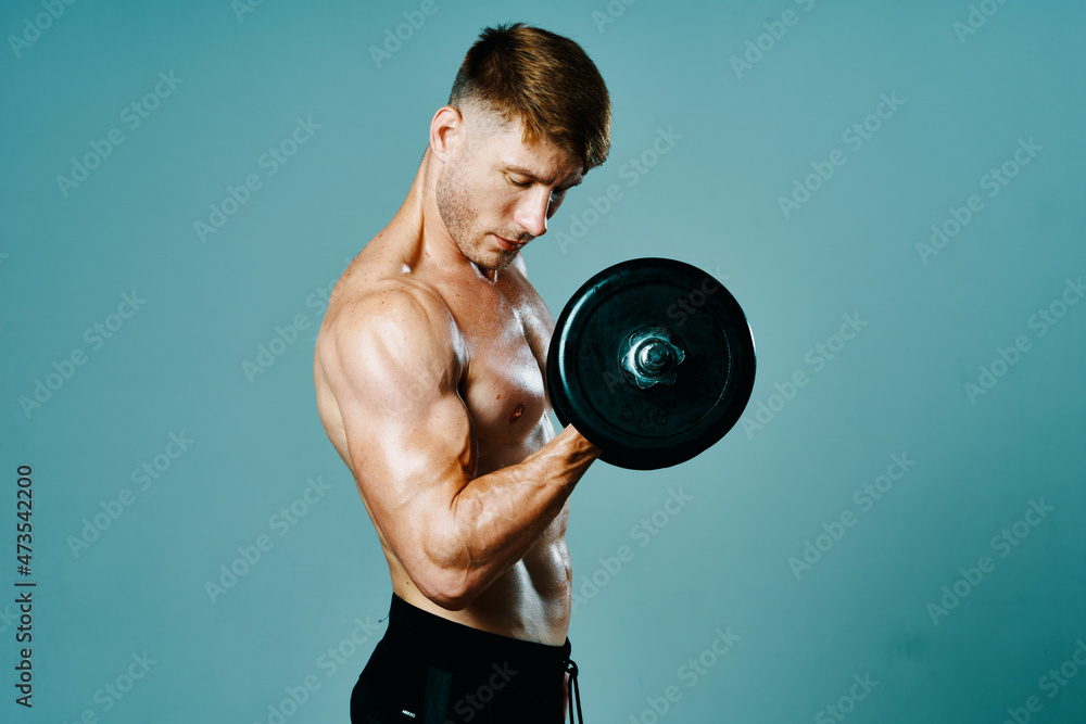 bodybuilder with a muscular body with dumbbells in his hands fitness