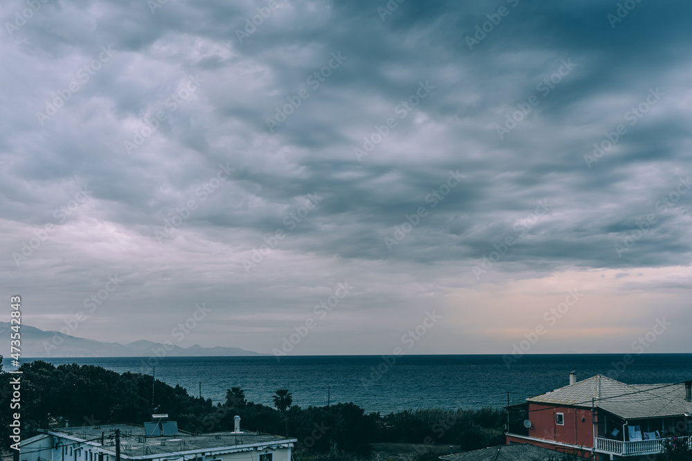 Fototapeta premium Clouds over the city on the sea