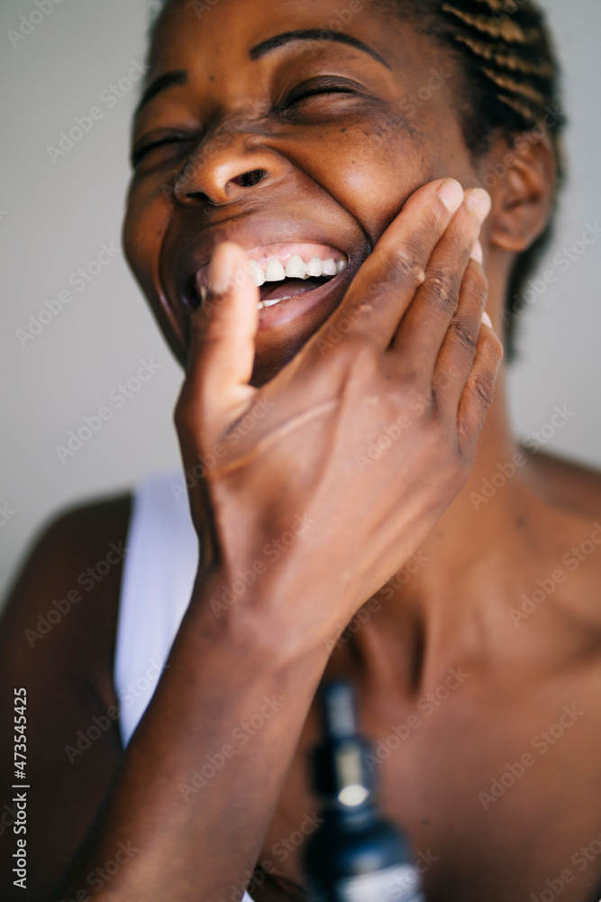 Afro woman smiling while touching face Afro woman smiling while touching face