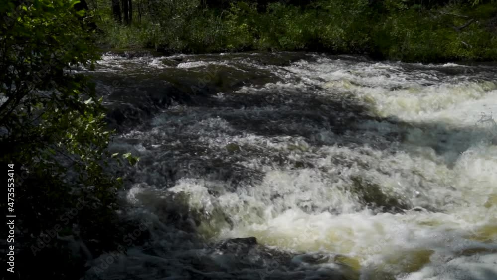 Slow motion river water flowing over the rocks; Ocqueoc Falls, rushing water over rocks in Northwest Michigan after months of rain in late summer--late morning. 456 Slow motion river water flowing over the rocks; Ocqueoc Falls, rushing water over rocks in Northwest Michigan after months of rain in late summer--late morning. 456