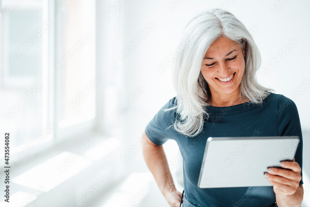 Smiling businesswoman using digital tablet at office Smiling businesswoman using digital tablet at office