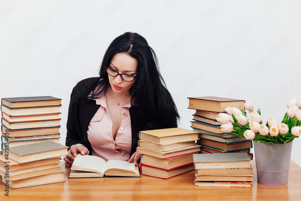 female teacher at a table with books for teaching female teacher at a table with books for teaching