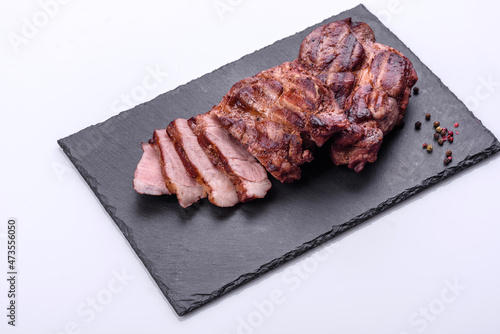 grilled beef steaks with spices on a dark cutting board