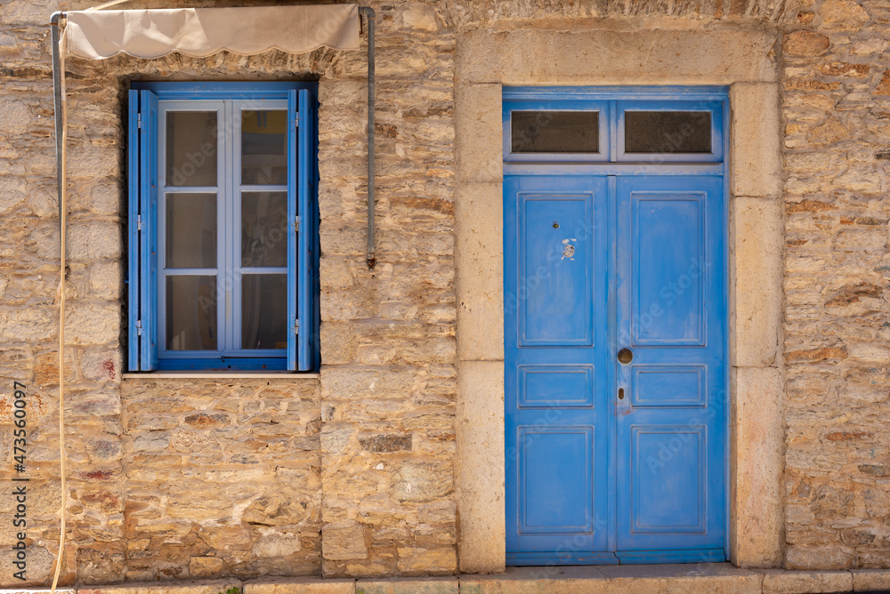 Greek house with blue door and window on Symi island in Greece