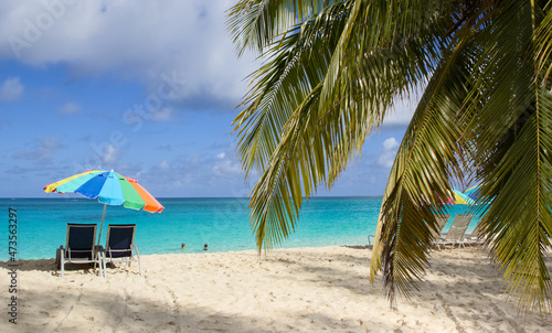 Beach chairs and colorful umbrella on Paradise beach in Nassau  Bahamas