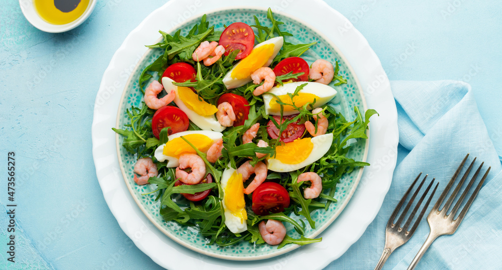 Arugula, cucumber, tomato, eggs and shrimp salad with soy sauce on ceramic plate. Selective focus. Top view. Arugula, cucumber, tomato, eggs and shrimp salad with soy sauce on ceramic plate. Selective focus. Top view.