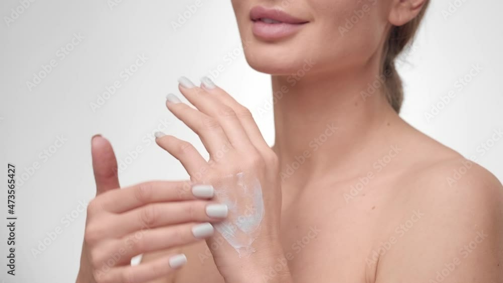 Young beautiful Caucasian woman applying hand cream and massage. Skin moisturizer, body lotion, soft hydration, daily beauty treatment. Skin care and body treatment concept. Young beautiful Caucasian woman applying hand cream and massage. Skin moisturizer, body lotion, soft hydration, daily beauty treatment. Skin care and body treatment concept.