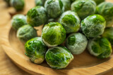 frozen frosty brussels sprouts on wooden plate closeup