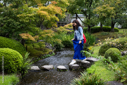 Japan, Kyoto, Woman on stepping stones in pond