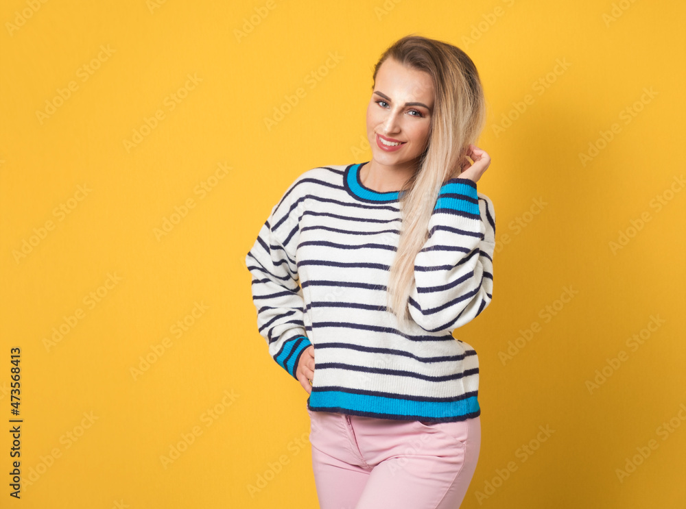 Portrait of beautiful young woman looking to camera, isolated on yellow background. Pretty girl, head and shoulders, front view Portrait of beautiful young woman looking to camera, isolated on yellow background. Pretty girl, head and shoulders, front view