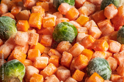 Frozen carrots and brussel sprout pieces closeup background