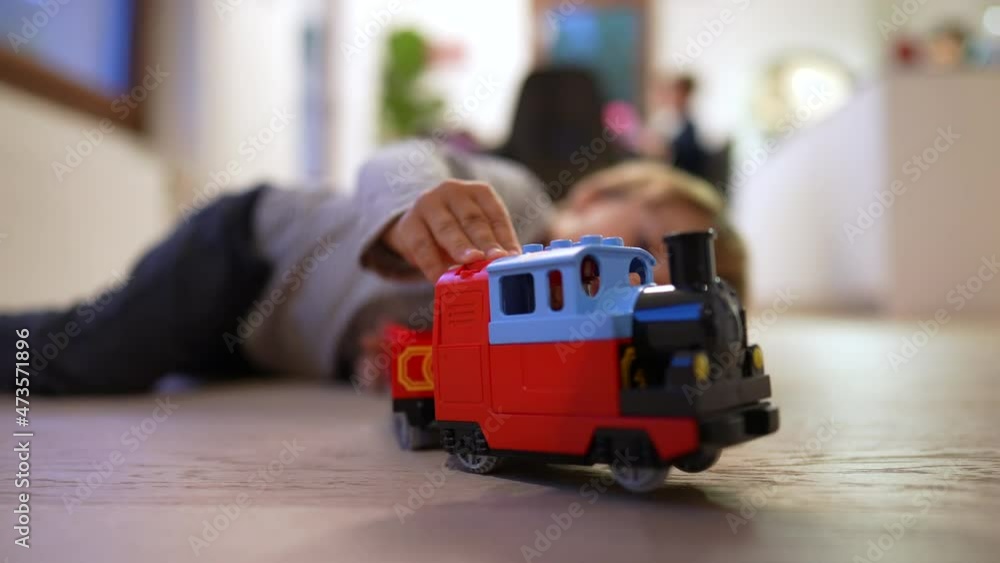 Child playing with toy on hardwood floor. kid plays at home Child playing with toy on hardwood floor. kid plays at home