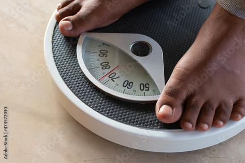 Male on the weight scale for check weight. Diet and weight loss concept.
